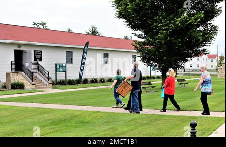 Un membre de la famille McCoy porte une caisse en bois datant de plus d'un siècle lors d'une visite à 8 juillet 2022, dans le Centre d'histoire de fort McCoy, dans la zone commémorative historique de fort McCoy, Wisconsin. La caisse a été donnée à fort McCoy par Alan McCoy, de Sparta, Wisconsin, qui est le petit-fils du major général Robert Bruce McCoy dont le nom est donné à fort McCoy. La caisse, qui transportait autrefois des seaux de saindoux, remonte à l'époque de Camp Emery Upton et Camp Robinson dans le Wisconsin vers 1910. Banque D'Images