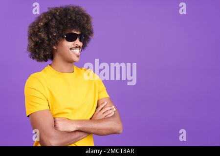 Smiley africain portant des lunettes de soleil posant avec les bras croisés Banque D'Images