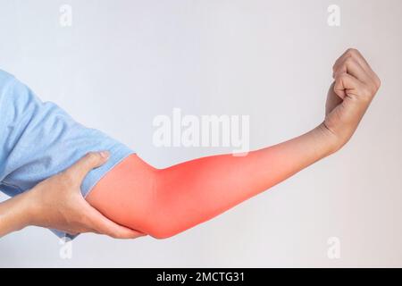 Douleur dans le bras supérieur du jeune homme d'Asie du Sud-est. Concept de douleur de coude et d'avant-bras, de blessure ou de problème musculaire. Banque D'Images