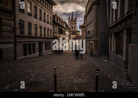 Photographie de rue d'une route pavée du centre ville de Lausanne historique Suisse vue panoramique maisons en pierre nuages cathédrale catholique église touristique vintage Banque D'Images