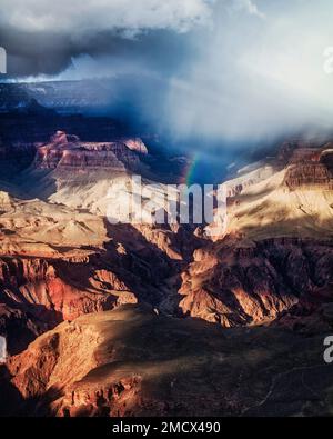 Une tempête passe au-dessus de Bright Angel Canyon, produisant un arc-en-ciel temporaire sur le plateau sud du Grand Canyon, en Arizona. Banque D'Images