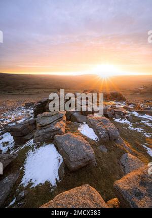 Great Staple Tor, parc national de Dartmoor, Devon, Royaume-Uni. 22nd janvier 2023. Météo au Royaume-Uni : des couleurs vives au lever du soleil éclairent les rochers de granit de la grande Staple Tor. Le ciel du matin a été recouvert d'une superbe couleur chaude alors qu'un front météo entrant s'est enroulé pour signaler un certain répit par rapport au temps froid glacial et aux cieux clairs qui ont récemment domié. Credit: Celia McMahon/Alamy Live News Banque D'Images