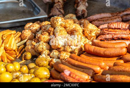 Appétissant viande cuite, saucisse barbecue et légumes dans une grande poêle à frire Banque D'Images