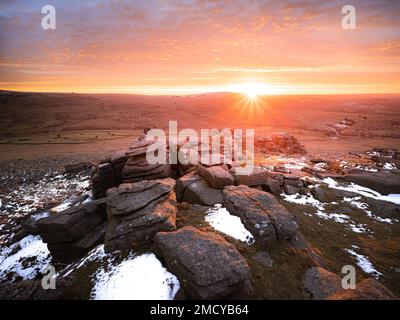 Great Staple Tor, parc national de Dartmoor, Devon, Royaume-Uni. 22nd janvier 2023. Météo au Royaume-Uni : des couleurs vives au lever du soleil éclairent les rochers de granit de la grande Staple Tor. Le ciel du matin a été recouvert d'une superbe couleur chaude alors qu'un front météo entrant s'est enroulé pour signaler un certain répit par rapport au temps froid glacial et aux cieux clairs qui ont récemment domié. Credit: Celia McMahon/Alamy Live News Banque D'Images