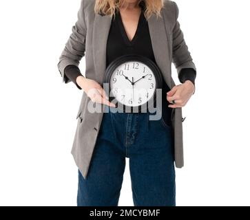 Concept de temps de menstruation.Une femme méconnaissable tient une montre dans le bas de l'abdomen.Isolé sur blanc Banque D'Images