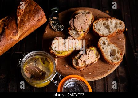 Baguette française au foie gras sur une surface en bois. Cuisson de la bruschetta avec du foie d'oie. Banque D'Images