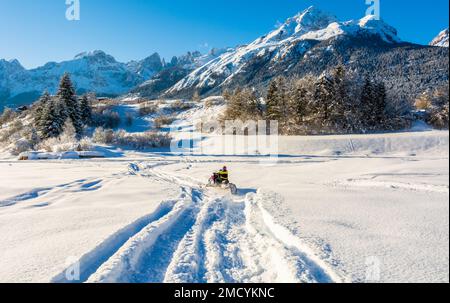 Homme en motoneige dans un paysage enneigé Trentin-Haut-Adige, Nord de l'Italie - Europe. Paysage d'hiver Banque D'Images