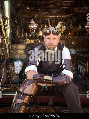 Un steampunk se trouve sur le côté de sa fourgonnette VW Camper montrant son intérieur magnifique. Science fiction, aventurier, temps voyageur concept. Banque D'Images