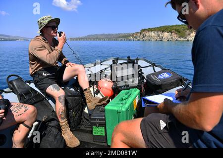 ACTIVITÉ DE SOUTIEN NAVAL BAIE SOUDA, Grèce (11 juillet 2022) Maître 2nd classe Zack Reisinger, à gauche, membre de l'équipe de construction sous-marine 1 (UCT-1) et affecté à la Force opérationnelle SIX HUIT (CTF 68), communique avec les plongeurs de l'UCT-1 lorsqu'ils effectuent une inspection sous-marine de la jetée, Tandis que l'officier de Petty 2nd classe Jordan Glensor, à droite, UCT-1, enregistre les informations relayées, au complexe OTAN Marathi, dans la baie de Souda, au 11 juillet 2022. En tant que plongeurs de Seabee, les techniciens de construction sous-marine UCT-1 construisent, inspectent et réparent des installations riveraines pour soutenir les opérations de la Marine et du corps des Marines Banque D'Images