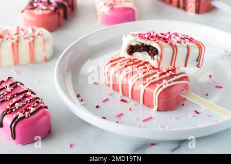 Cakesicles de la Saint-Valentin sur une assiette avec des saupoudrées d'une bouchée. Banque D'Images