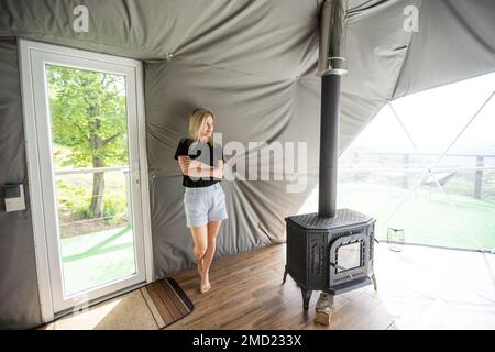 femme dans une tente dôme. Concept de mode de vie de vacances de luxe. Banque D'Images