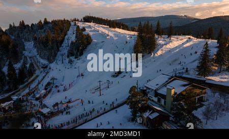 Vue aérienne d'une piste de ski en haut de la montagne en hiver au coucher du soleil. La photographie a été prise à partir d'un drone à une altitude plus élevée. Vue aérienne o Banque D'Images