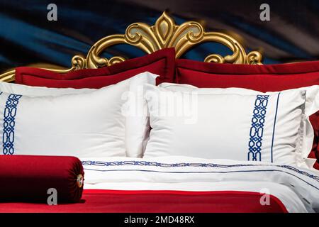Matelas et oreillers couverts dans la chambre. Tête de lit en feuille d'or Banque D'Images