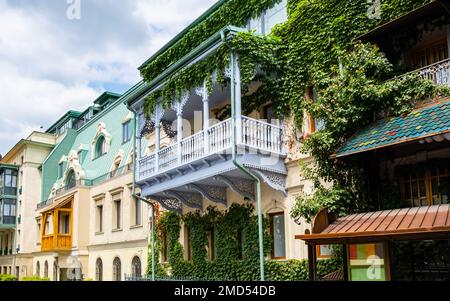 Balcon en bois sculpté et bâtiments colorés dans la ville historique de Tbilissi, en Géorgie. Décoration traditionnelle de la maison géorgienne dans la vieille ville de Tiflis. Ivy sur le mur Banque D'Images