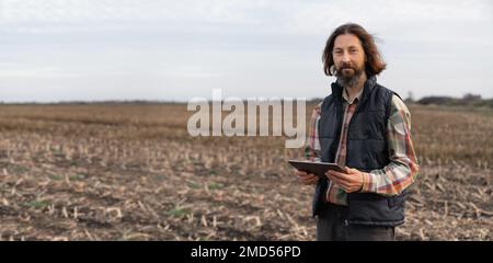 Agriculteur avec une tablette numérique sur un terrain. Agriculture intelligente et agriculture numérique Banque D'Images