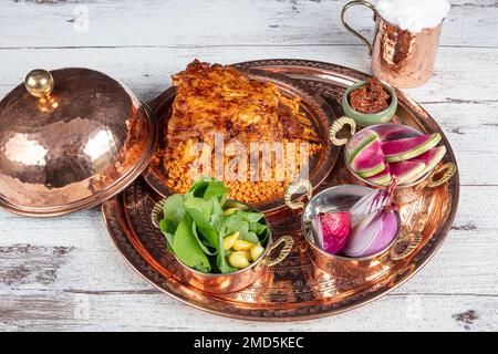 Côtelettes d'agneau sur le pilaf de bulgur. Côtes farcies isolées sur fond noir. Nom turc: 'Kaburga dolmasi'. Banque D'Images