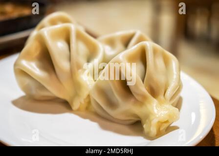 Khinkali rempli de viande hachée sur une assiette blanche. Gros plan sur le dépolement traditionnel à Tbilissi, en Géorgie. Cuisine nationale géorgienne Banque D'Images