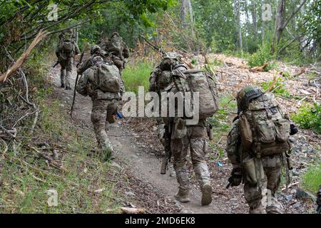 Les agents spéciaux de l'équipe des armes et tactiques spéciales du FBI d'Anchorage se déplacent vers un sol plus élevé tout en patrouilant au cours d'un exercice de formation sur les opérations rurales à la base conjointe Elmendorf-Richardson, Alaska, 13 juillet 2022. Les vastes zones de formation du JBER, étendues et austères, ont constitué un cadre idéal pour les équipes SWAT locales chargées de l'application de la loi, qui ont perfectionné leurs compétences en exploitation rurale, la planification des tâches, la reconnaissance, les procédures de sécurité des hélicoptères, la navigation terrestre, mouvement d'équipe et patrouille. Banque D'Images