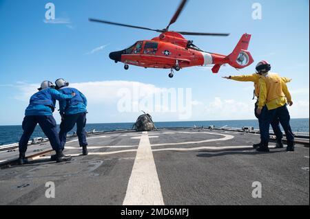 A ÉTATS-UNIS Le dauphin MH-65 de la Garde côtière, un atout de l’Escadron tactique d’interception d’hélicoptères de la Garde côtière (HITRON), survole le pont de vol de l’ours de garde-côtes (WMEC 901), dans l’océan Atlantique (13 juillet 2022). L'ours et son équipage sont déployés pour soutenir l'Organisation des pêches de l'Atlantique Nord, décourager la pêche illégale et accroître la sensibilisation au domaine maritime, en collaboration avec les pays alliés. Banque D'Images