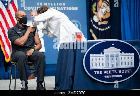 Reportage: DC Firefighter et EMT Gerald Bunn reçoit un vaccin COVID-19 de la RN Elizabeth Galloway lors d'un événement avec le Président Joe Biden, célébrant le 50 millionième vaccin COVID-19 jeudi 25 février 2021, dans l'Auditorium de la Cour du Sud, dans le bâtiment du Bureau exécutif Eisenhower à la Maison Blanche. Banque D'Images