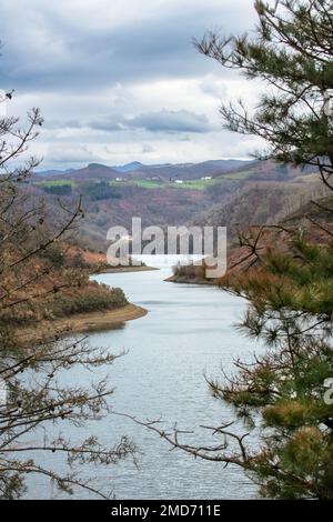 Une vue sur un beau lac entouré de montagnes couvertes de fougères rouges. Banque D'Images