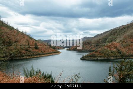 Une vue sur un beau lac entouré de montagnes couvertes de fougères rouges. Banque D'Images