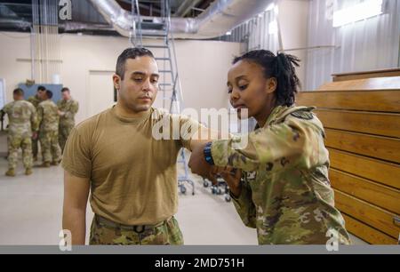 ÉTATS-UNIS Alana Johnson, spécialiste des soins de santé du bataillon des troupes spéciales 369th de la Garde nationale de l'armée de New York, démontre une technique d'enveloppement tactique de soins occasionnels sur le sergent David Segarra, un medic de combat avec la Brigade de soutien 369th, lors de l'entraînement annuel au Centre d'entraînement national de la Garde nationale de fort Indiantown Gap, Jonestown, PA, 13 juillet 2022. L'état-major du bataillon des troupes spéciales de 369th est un petit état-major de bataillon qui fonctionne avec efficacité et efficience en tant qu'équipe, contrôlant diverses unités en fonction de la situation opérationnelle. Banque D'Images