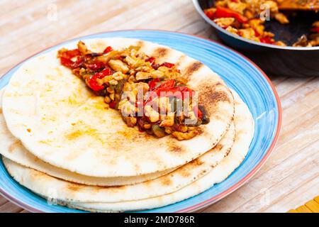 Fajitas au poulet avec poivrons et oignons servis sur des tortillas Banque D'Images