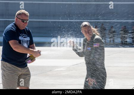 Le Sgt Kathy Backlund, maître de charge de l'escadron de transport aérien 192nd, est aspergé de champagne après son dernier vol « fini » dans le C-130 Hercules, à la base de la Garde nationale aérienne du Nevada, à Reno, au Nevada, sur 14 juillet 2022. C'est la tradition de vaporiser des tuyaux d'incendie et du champagne à l'arrivée à la base de leur dernier vol « fini » dans l'avion. Backlund devrait prendre sa retraite plus tard cette année après 22 ans de service. Banque D'Images