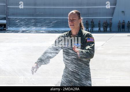 Le Sgt Kathy Backlund, maître de charge de l'escadron de transport aérien 192nd, est aspergé de champagne après son dernier vol « fini » dans le C-130 Hercules, à la base de la Garde nationale aérienne du Nevada, à Reno, au Nevada, sur 14 juillet 2022. C'est la tradition de vaporiser des tuyaux d'incendie et du champagne à l'arrivée à la base de leur dernier vol « fini » dans l'avion. Backlund devrait prendre sa retraite plus tard cette année après 22 ans de service. Banque D'Images