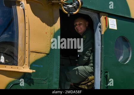 Un pilote aérien hongrois attend dans un MI-17 hongrois pendant l'exercice Jolly Vihar près de la base aérienne de Pápa, Hongrie, 14 juillet 2022. Les troupes hongroises ont fourni des services d'incendie d'urgence sur le terrain d'entraînement pendant que les États-Unis La Force aérienne HH-60G Pave Hawks affectée à l'escadron de la génération de secours 56th a mené une formation sur le système d'armes. Banque D'Images