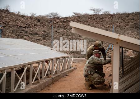 ÉTATS-UNIS Les aviateurs de la Force aérienne de l'escadron de la base aérienne expéditionnaire 776th évaluent les réparations électriques et l'entretien des panneaux solaires lors d'une visite au village de Chabelley, à Djibouti (15 juillet 2022). L'équipe a inspecté et effectué des essais opérationnels initiaux sur le câblage du système actuel de panneaux solaires pour voir où des améliorations peuvent être apportées. Banque D'Images