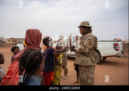 ÉTATS-UNIS Tech. De la Force aérienne Le Sgt Rica Jackson, officier non commandant de l’Escadron de la base aérienne expéditionnaire du 776th septembre chargé des systèmes électriques, enseigne un jeu de rime de patty-cake aux enfants lors d’une visite au village de Chabelley, à Djibouti, au 15 juillet 2022. Grâce à des engagements de leadership clés et à des visites sur place, les aviateurs du groupe expéditionnaire aérien 449th sollicitent la rétroaction des villages locaux, des aînés et des représentants régionaux pour établir la confiance et renforcer les partenariats. Banque D'Images