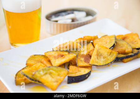 Aubergine frite avec du miel et une bière Banque D'Images