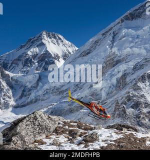 CAMP DE BASE DE L'EVEREST TREK/NÉPAL - 31 OCTOBRE 2015 : hélicoptère de sauvetage dans les hautes montagnes de l'Himalaya. Hélicoptère de sauvetage rouge en vol près du sommet de l'Everest sur un Banque D'Images