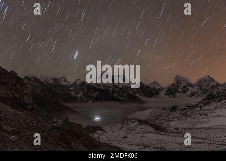 Des étoiles qui surent la chaîne montagneuse himalayenne illuminées par un clair de lune lumineux. Magnifique paysage de montagne de nuit avec mouvement des étoiles flou. Pistes étoiles Banque D'Images