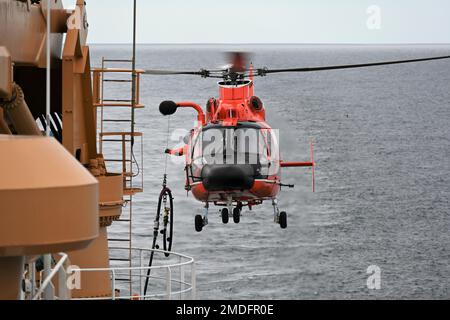 Des membres d'équipage du Cutter Healy de la Garde côtière et de la station aérienne Kodiak effectuent un ravitaillement en vol en hélicoptère près du cercle arctique sur 22 juillet 2022. La formation est régulièrement menée pour maintenir les qualifications de l'équipage à bord des deux biens et maintenir la maîtrise d'une variété d'évolutions. ÉTATS-UNIS Photo de la Garde côtière auxiliaire par Deborah Cordone. Banque D'Images