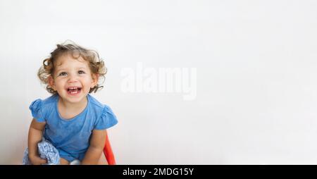 Portrait d'une jolie petite fille blanche de race blanche aux cheveux blonds, souriant et amusant, isolée sur un fond blanc pur Banque D'Images