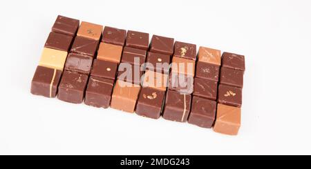 Assortiment de variétés de pralines au chocolat artisanal brun fin en fond blanc avec vue de dessus plate Banque D'Images