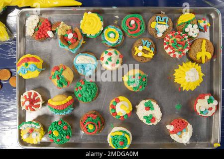 220723-N-CM110-1072 OCÉAN PACIFIQUE (23 juillet 2022) – des marins décorent des cupcakes lors d'un événement de Noël en juillet sur les ponts du mess à bord du porte-avions amphibie USS Tripoli (LHA 7), 23 juillet 2022. Tripoli opère dans la zone d'opérations de la flotte américaine 7th afin d'améliorer l'interopérabilité avec ses alliés et ses partenaires et de servir de force de réaction prête à l'emploi pour défendre la paix et maintenir la stabilité dans la région Indo-Pacifique. Banque D'Images