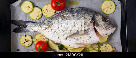 Poisson dorado cru avec des ingrédients pour faire sur une plaque de cuisson. Vue de dessus, bannière Banque D'Images