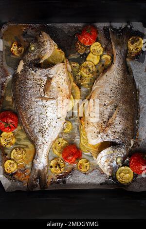 Poisson dorado cuit avec légumes sur plaque à pâtisserie. Vue de dessus Banque D'Images