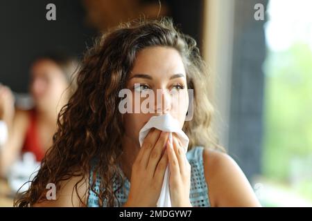 Femme nettoyant la bouche avec une serviette dans un restaurant Banque D'Images