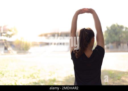 Les athlètes étirent leurs muscles pour se réchauffer ou faire de l'exercice dans le parc le matin, l'exercice pour un mode de vie sain concept. Banque D'Images