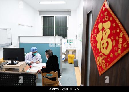 Guangzhou, province chinoise de Guangdong. 21st janvier 2023. Un médecin parle avec un patient au service des urgences de l'hôpital provincial de médecine chinoise de Guangdong à Guangzhou, dans la province de Guangdong, dans le sud de la Chine, le 21 janvier 2023. Le personnel médical s'en tient à leurs postes pendant les vacances du Festival de printemps. Credit: Deng Hua/Xinhua/Alay Live News Banque D'Images