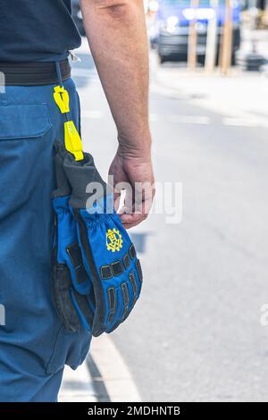 Partie d'un bénévole de la 'Technisches Hilfswerk' (Agence fédérale de secours technique) avec le signe 'THW' sur ses gants Banque D'Images