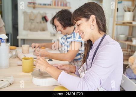 Femmes faisant de la poterie à la main dans une classe de poterie. Concept d'artisanat et d'hobbies. Banque D'Images