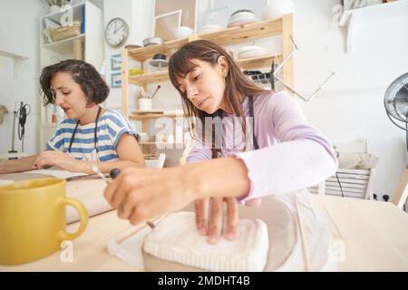 Femmes faisant de la poterie à la main dans une classe de poterie. Concept d'artisanat et d'hobbies. Banque D'Images