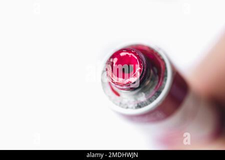 Tube en acrylique métallique avec peinture rose pour dessiner des gros plans sur fond blanc. Banque D'Images