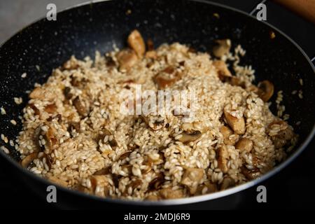 Processus de cuisson du risotto. Riz Arborio dans une poêle à frire dans la cuisine maison. Plat de cuisine italienne Banque D'Images